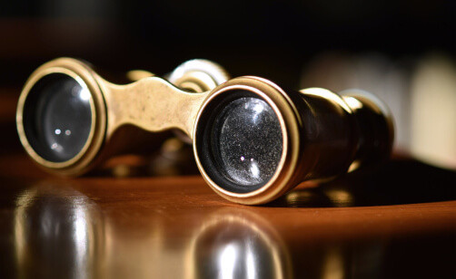 Opera glasses on top of a wood table