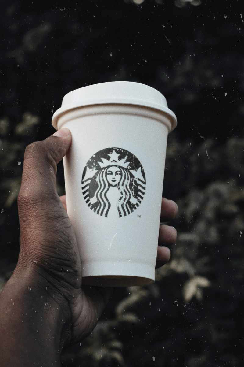 Image of a Starbucks cup being held up in a man's hand