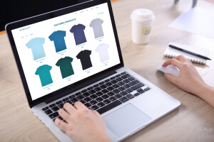  Image of hands viewing a t-shirt gallery on a eCommerce website on a laptop