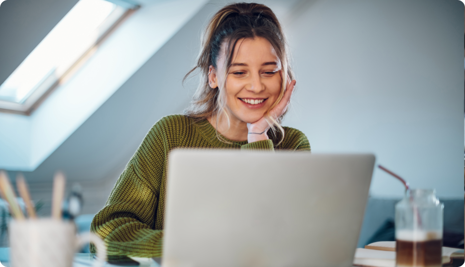 woman smiling while looking at laptop