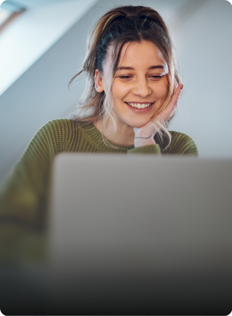 woman smiling while looking at laptop