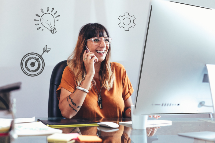 Female business owner working on a computer while speaking on the phone