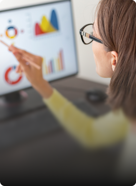 woman pointing at graphs on computer screen