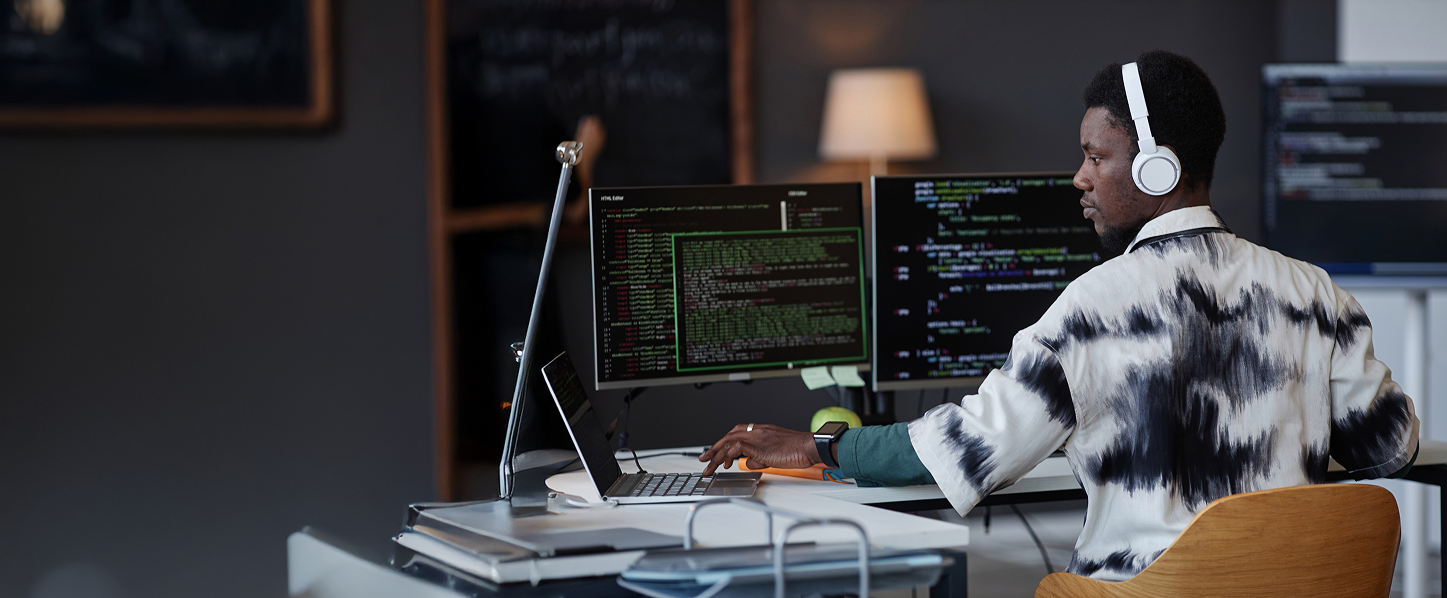 Man programming on several devices