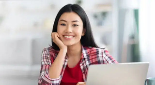 woman smiling with laptop in front of her