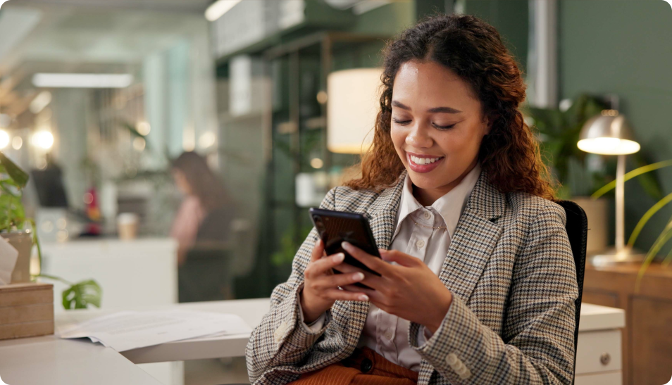 woman smiling while looking at smartphone