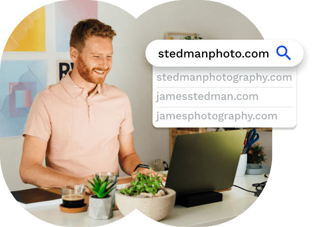 Smiling man working on laptop searching for a domain