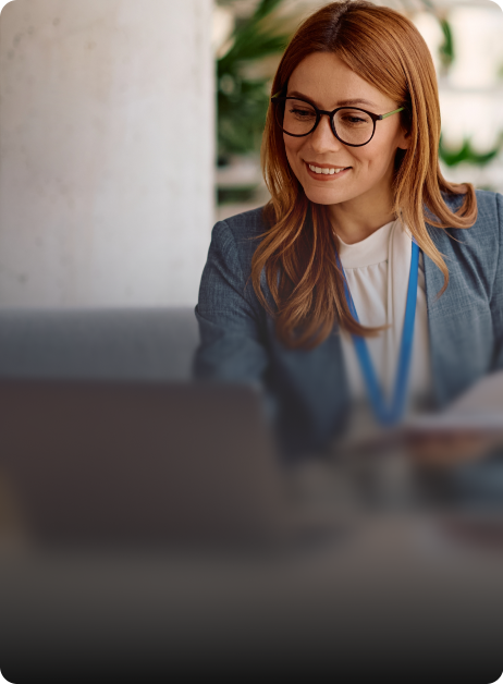 woman smiling while looking at laptop