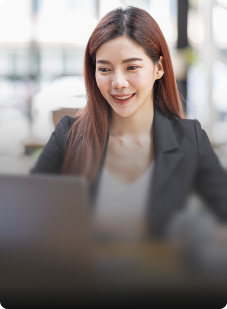 woman smiling while looking at laptop