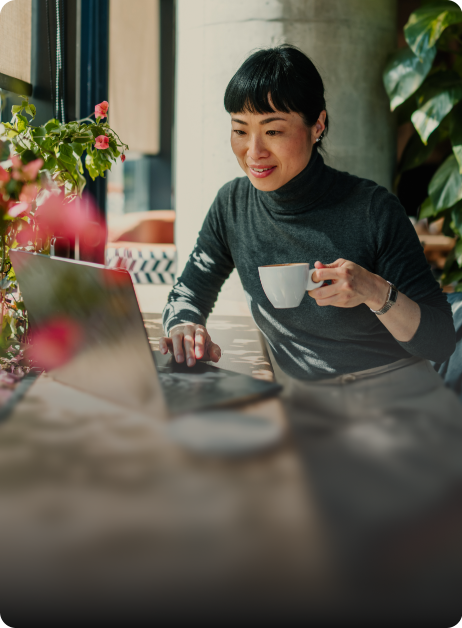 woman on laptop holding a cup