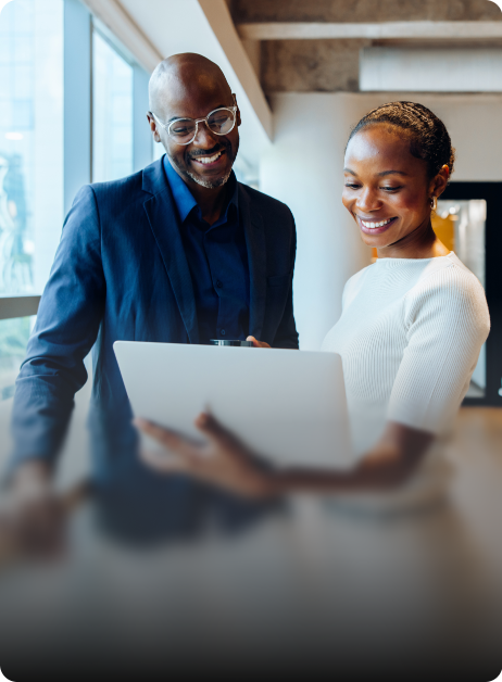 smiling businesswoman showing a smiling businessman a laptop