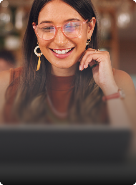 woman smiling while looking at laptop